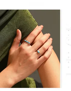 Detailed view of silver rings featuring turquoise stones and beaded texture design