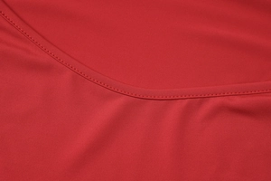 Vista macro dettagliata delle cuciture e del tessuto rosso elastico sull'abito