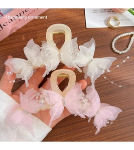 Detail of large butterfly hair claw clips with organza wings and pearl accents