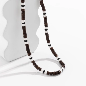 Bohemian men's necklace with brown and black-and-white clay and wood beads on a white stand