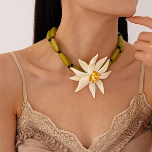 Detail of chunky resin floral choker with green beads and a white flower pendant