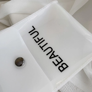Dettaglio della borsa a tracolla in PVC trasparente con scritta BEAUTIFUL e bottone in metallo