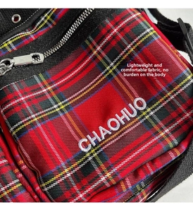 Detail of red plaid canvas fabric with CHAOHUO embroidery and metallic zipper