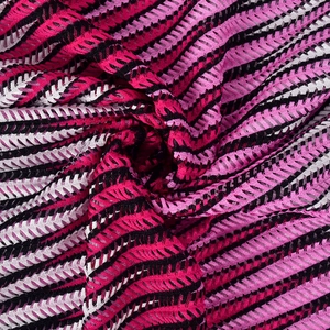Detailaufnahme von geometrischem Mesh-Strickstoff mit kontrastierenden Wellenmustern