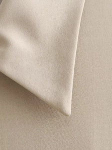 Macro detail of high-density light khaki fabric showing premium weave texture and quality