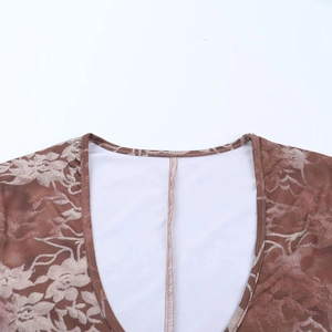 Detailed close-up of deep V-neckline with brown floral print and white lining