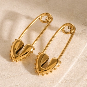 Detailed macro view of 18k gold-plated heart safety pin earrings with beaded edge craft