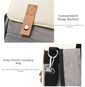 Detail of stroller organizer with magnetic buckle and metal hooks on gray woven fabric
