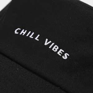 Black cotton bucket hat featuring white Chill Vibes embroidery in streetwear style