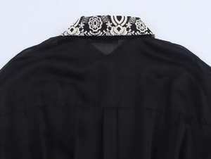 Detail of elegant black dress featuring ethnic embroidery on the collar and back