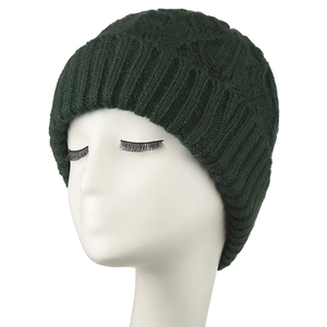 Detail of dark green chunky knit beanie showing thick textured cable patterns and cuff
