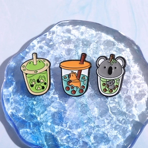 Cute enamel pins featuring cartoon animals like frogs and foxes in bubble tea cups
