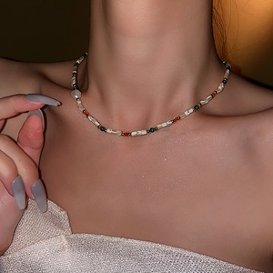 Close-up of baroque pearl necklace with colorful beads on model neck