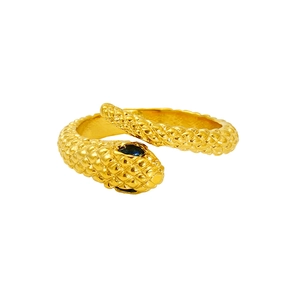 Detail of gold snake ring with scale texture and dark gemstone eyes on white background