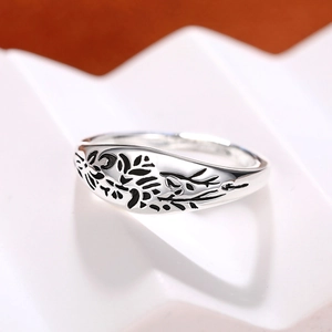 Macro shot of silver ring featuring vintage black etched flower and leaf patterns