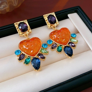 Gros plan détaillé de boucles d'oreilles vintage en or avec pierres colorées en cœur
