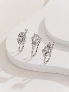 Detail view of silver nose rings set with flower, teardrop, and leaf zircon designs