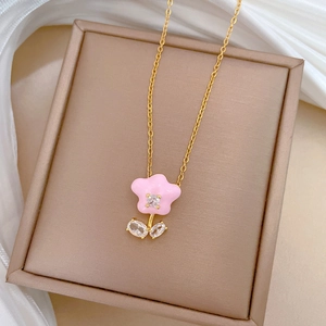 Luxurious gold chain necklace with pink flower zircon pendant on white silk background