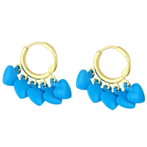 Détail de boucles d'oreilles créoles dorées avec plusieurs breloques cœur bleues