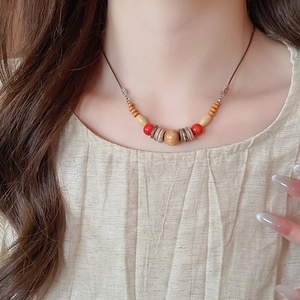 Gros plan sur un collier ethnique avec perles de cristal rouges et perles en bois