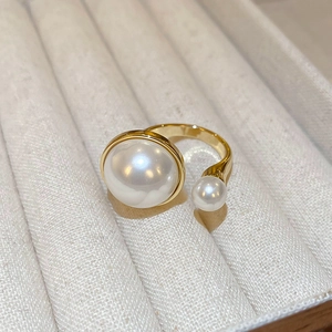 Close-up of gold-plated double pearl open ring displayed in a beige velvet jewelry box