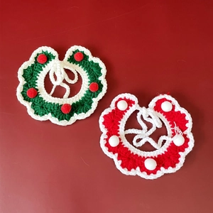 Détail de colliers de Noël tricotés main pour animaux en rouge et vert avec pompons