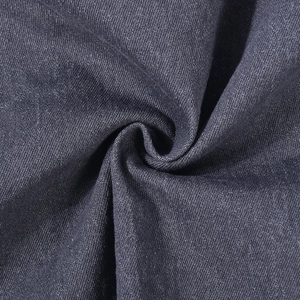 Macro shot of dark blue denim fabric showing twill weave texture and material density
