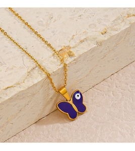 Macro detail of gold necklace with purple butterfly pendant and evil eye pattern