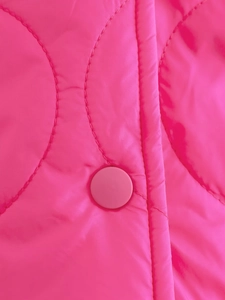 Dettaglio della giacca trapuntata fucsia con bottone a pressione e cuciture tonde