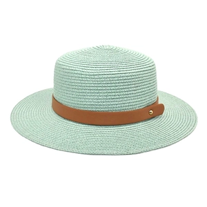 Detail of mint green woven straw hat with brown leather band and gold rivet accent