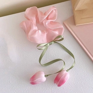 Rosa Tulpen Organza-Haargummi mit grünem Band und 3D-Blumenanhängern auf weißem Tisch