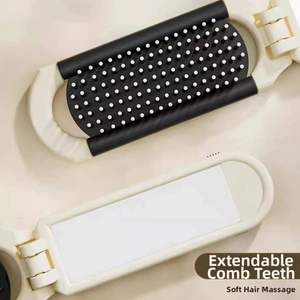 Close-up of portable folding hairbrush with cream shell and soft massage bristles