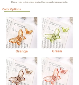 Detail view of butterfly hair claws in four colors on a vintage book background