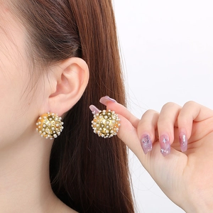 Elegant gold spherical stud earrings featuring high-luster pearls for a modern luxury look