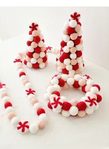 Detailed view of handmade wool felt Christmas trees, wreath and garland set in red and white