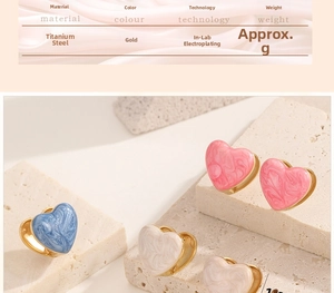 Detailed view of heart-shaped earrings in blue, pink and white with gold finish