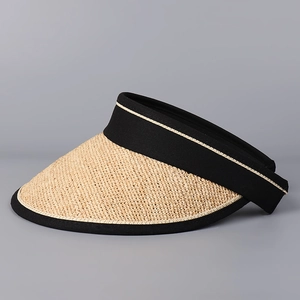 Détail de la texture en raphia tissé et bordure en tissu noir sur un chapeau visière