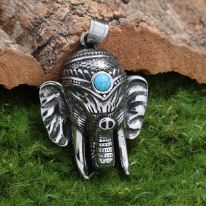 Pendentif éléphant en acier inoxydable avec turquoise bleue sur fond de mousse et écorce