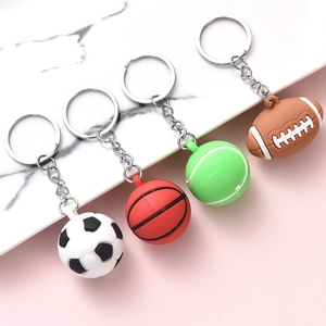 Mini sports ball keychains with football basketball tennis and rugby designs on marble