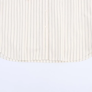 Detail of curved hem and buttoned placket on vintage striped loose-fit cotton shirt