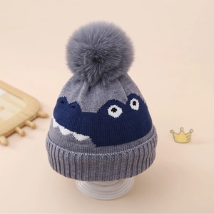 Détail du bonnet tricoté pour enfant avec pompon en fausse fourrure et textures de tricot