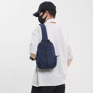 Modern dark blue oxford fabric crossbody chest bag for men shown on model's back