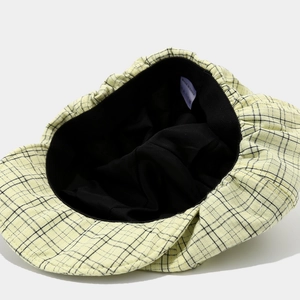Internal view of the yellow plaid newsboy cap showing black lining and craftsmanship