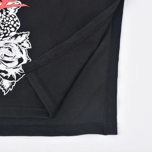 Détail macro de la fente latérale et de l'imprimé floral sur un crop top noir en maille