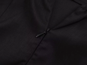 Détail de la fermeture éclair invisible et du tissu en sergé de la robe moulante noire