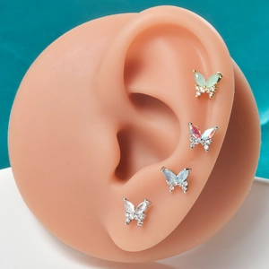 Macro detail of butterfly stud earrings with colorful zirconia inlay on ear model