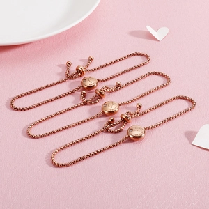 Rose gold zodiac bracelets with ARIES TAURUS GEMINI charms on pink background