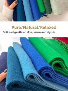 Close-up of thick wool scarves showing soft texture and long tassels in vibrant colors