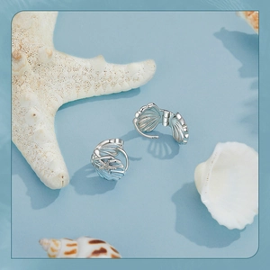 Detail shot of ocean theme shell and starfish earrings with blue enamel and zircons