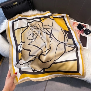 Dettaglio di foulard in seta con rose nere su sfondo satinato beige ed elegante